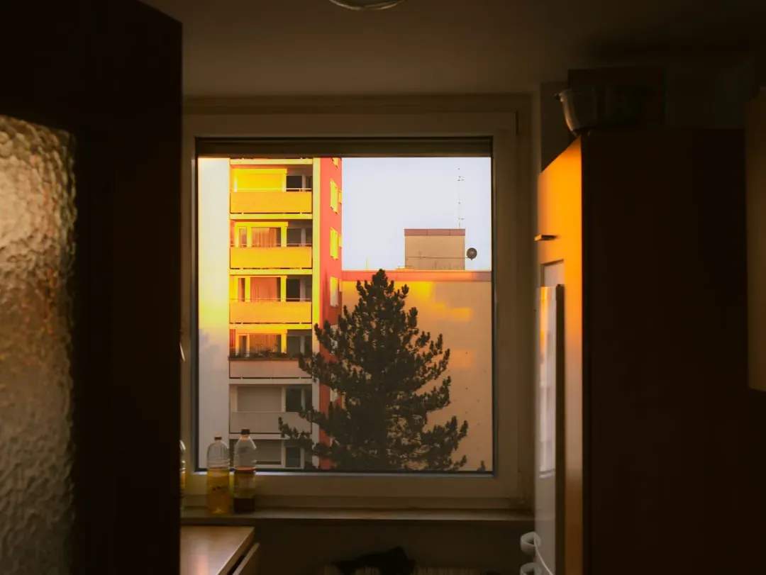 Open windows in a rental apartment allowing fresh outdoor air to flow inside on a clear day, demonstrating natural ventilatio