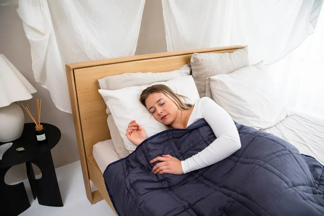 Person sleeping peacefully in dark bedroom with air purifier on nightstand, demonstrating science-backed air purifier benefit