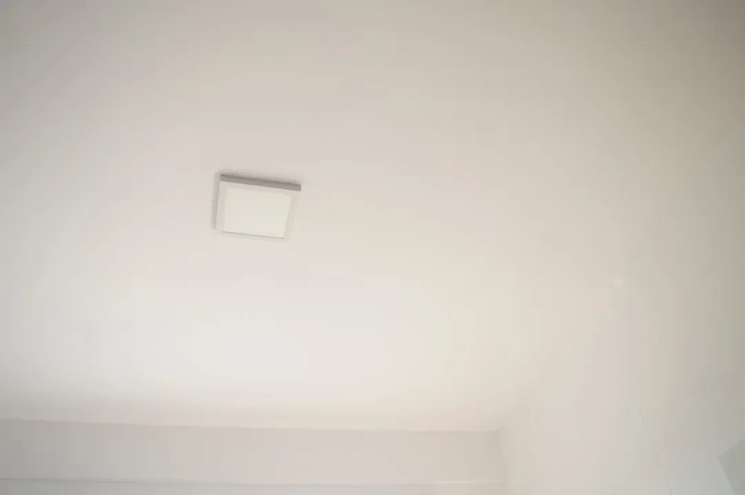 Homeowner using portable air quality monitor to test DIY air quality across multiple rooms, demonstrating home testing method